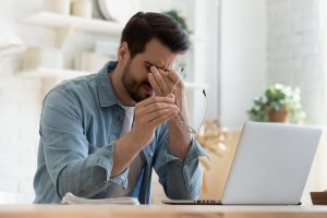 Vitalstoff Balancierung – Mann sitzt erschöpft am Schreibtisch, symbolisierend einen möglichen Vitalstoffmangel und dessen Auswirkungen.