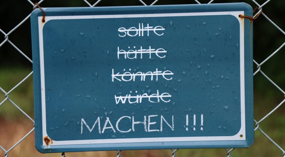 Beruflicher Werdegang: Motivation zum Handeln – Schild mit inspirierendem Zitat vor einem Zaun. Beruflicher Werdegang: Motivation zum Handeln – Schild mit inspirierendem Zitat vor einem Zaun.