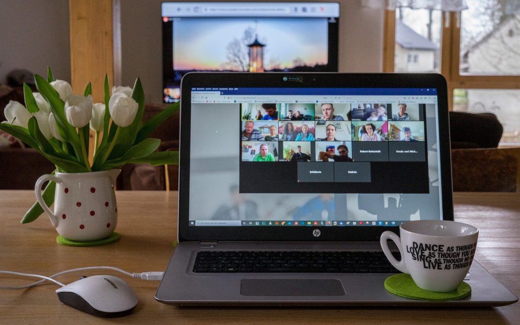 AGB – Geöffneter Laptop auf einem Tisch während einer Videokonferenz, symbolisch für digitale Absprachen und Vertragsinhalte.