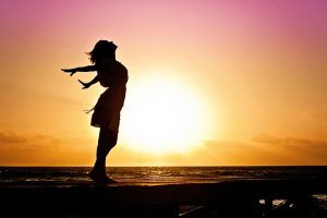 Woman standing empracing the power of the sunrise