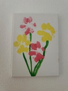 Ein Blumenstrauß aus gelben udn rosa blumen, mit Blüten asu Pfoten-Abdrücken und grünen Stengeln