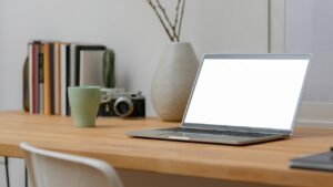table with a laptop and a cup of tea on it in order to online-meet
