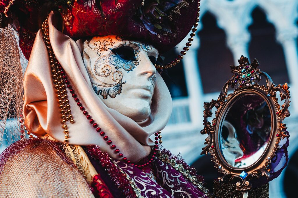 Eine venetianische Karnevalsfigur mit Maske, prunkvollem Gewand und Geschmeide