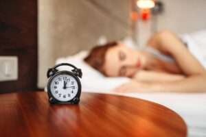 Clock with women in the background going to sleep