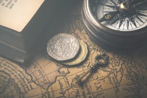 a map, some coins, a key and the compas for reflecting the past and orientation towards future adventures